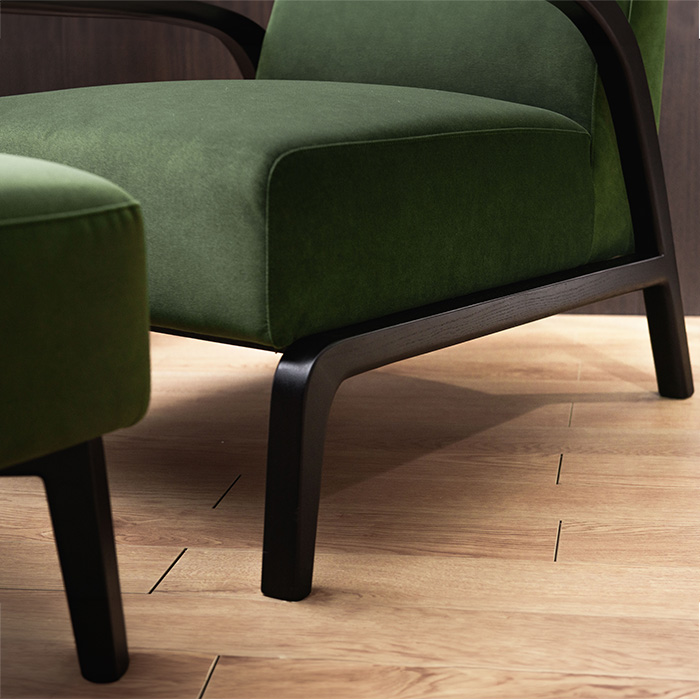 Sillón moderno de terciopelo verde con otomana