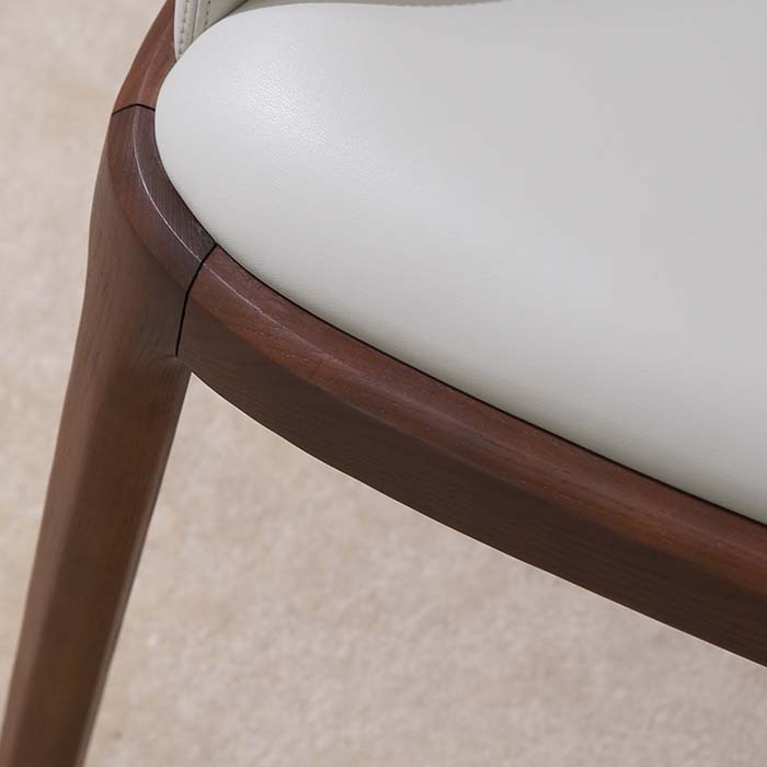 Sillón de comedor moderno tapizado en cuero blanco con patas de madera